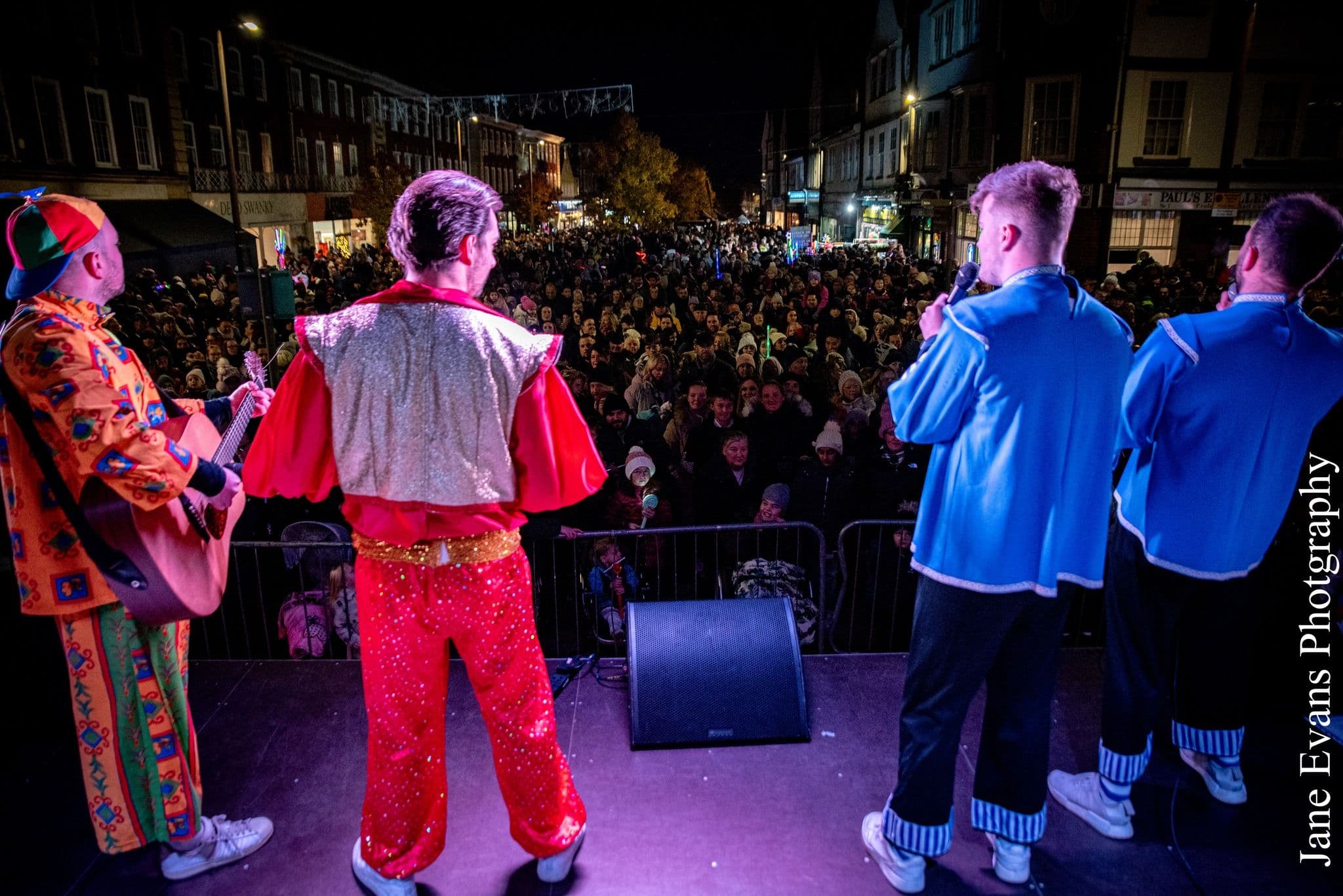 Band in costume performing to a packed night-time crowd on the Old Town Live stage in Stevenage